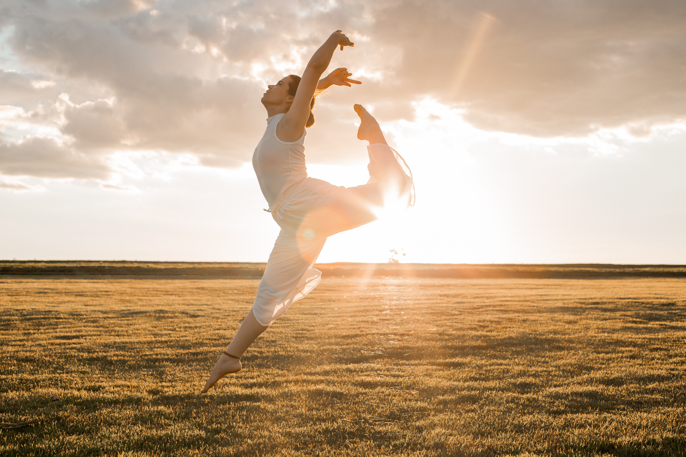 Young Woman in White Tank Top Doing Contemporary Dance on Grass Field